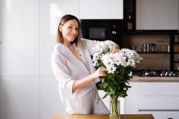 Woman puts flowers in vase