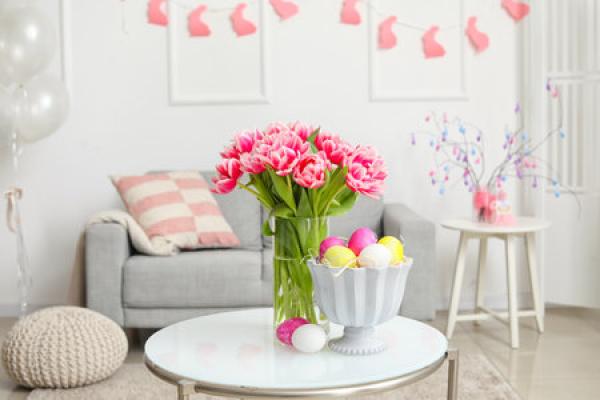 A living room decorated for Easter. In the center of the room there is an arrangement of pink tulips
